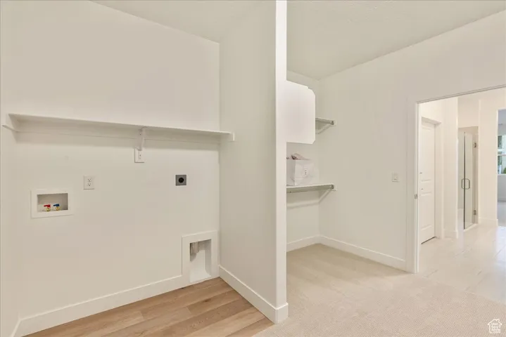 Laundry room featuring washer hookup, hookup for an electric dryer, and light hardwood / wood-style flooring