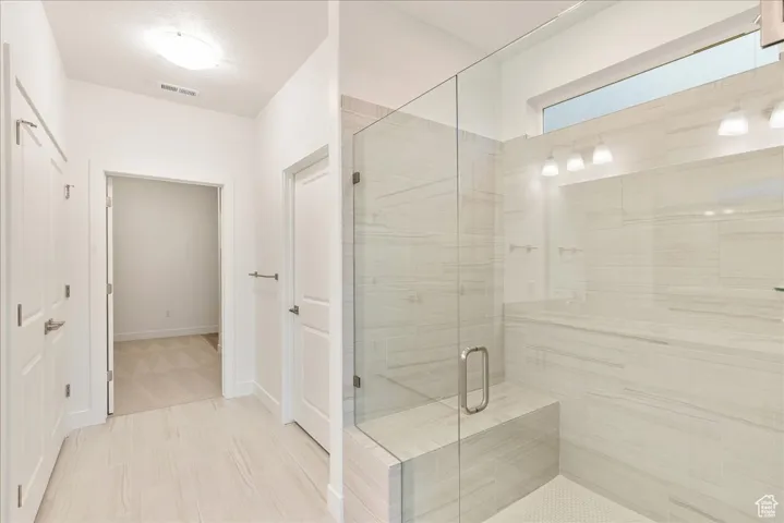 Primary bathroom with walk in shower and bench seat and Euro glass and double sinks