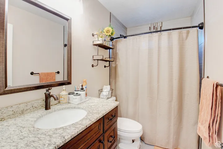 Bathroom featuring vanity, a textured ceiling, and toilet