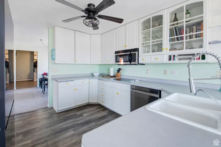 Kitchen featuring white cabinetry, sink, dark hardwood / wood-style flooring, ceiling fan, and stainless steel appliances