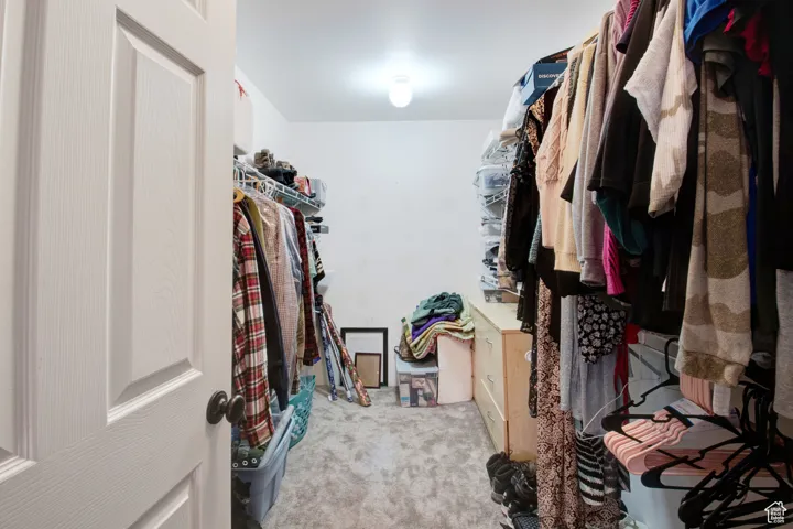 Walk in closet featuring light carpet
