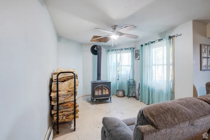 Living area featuring ceiling fan and a wood stove