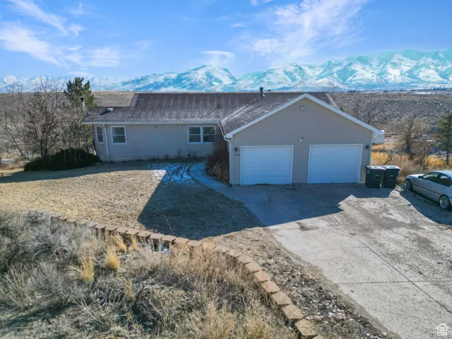 View of front of home with a garage and a mountain view