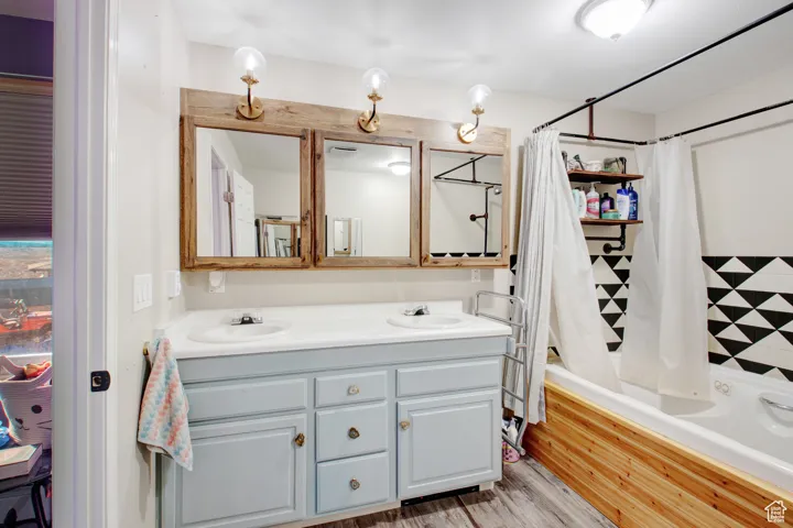 Bathroom featuring vanity, wood-type flooring, and shower / tub combo