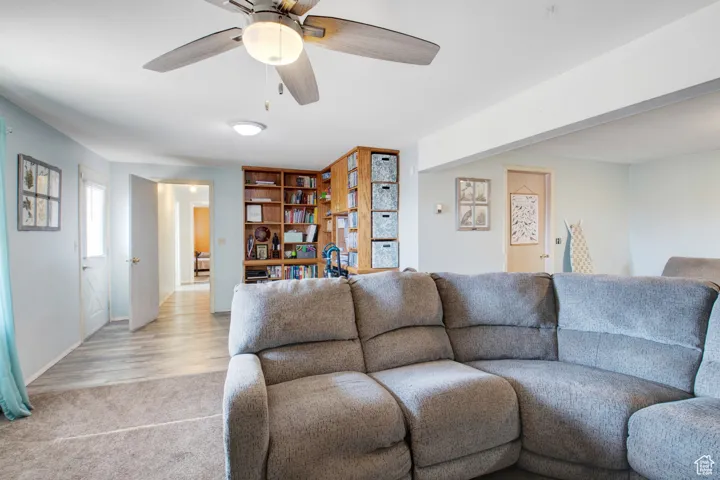 Carpeted living room featuring ceiling fan