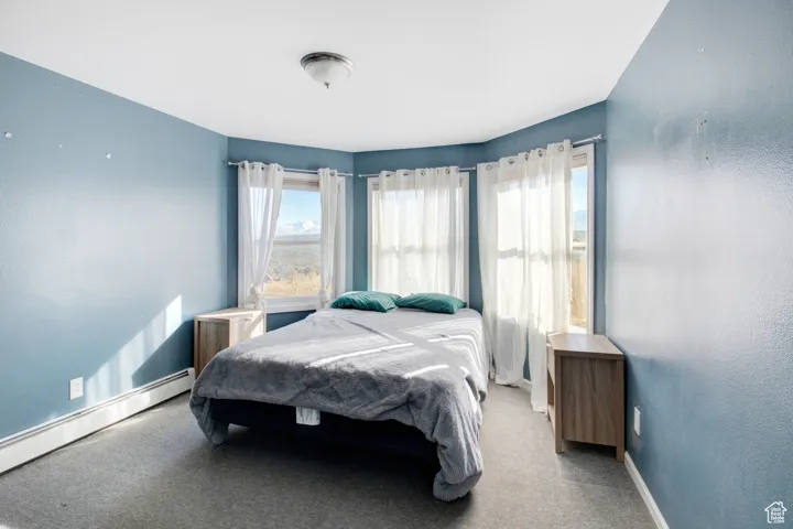 Carpeted bedroom with a baseboard radiator