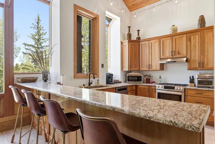 Kitchen featuring a large breakfast bar with stone countertops and wood cabinetry