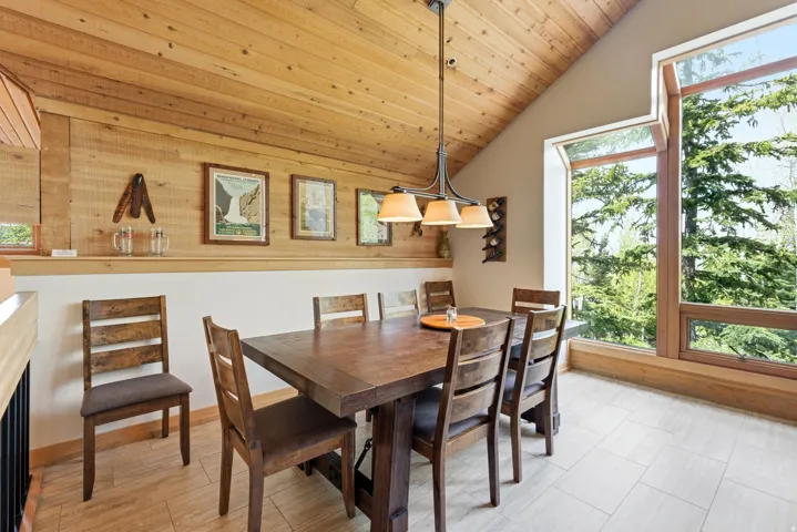Vaulted wood-paneled ceiling with a linear chandelier