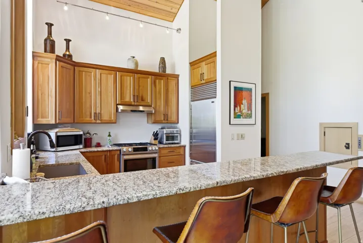 Kitchen featuring wood cabinetry, a stainless steel range, and a built-in stainless steel refrigerator