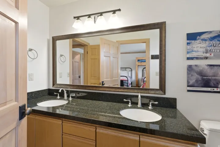 Double vanity featuring a dark granite countertop and two undermount sinks with brushed nickel faucets