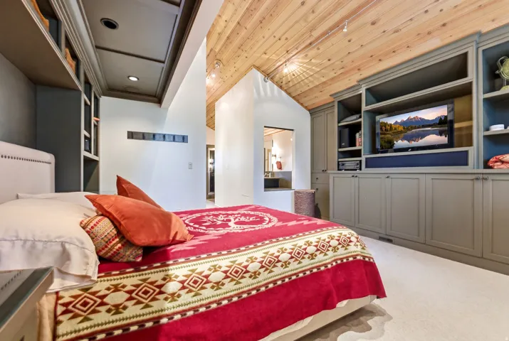 Vaulted wood-finish ceilings complement built-in cabinetry with open shelving and closed storage