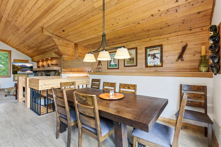 Spacious dining area featuring a wood-finish ceiling, wood-finish flooring, and an iron chandelier