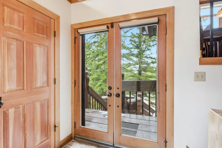 Double French doors with wood framing, offering access to an outdoor deck