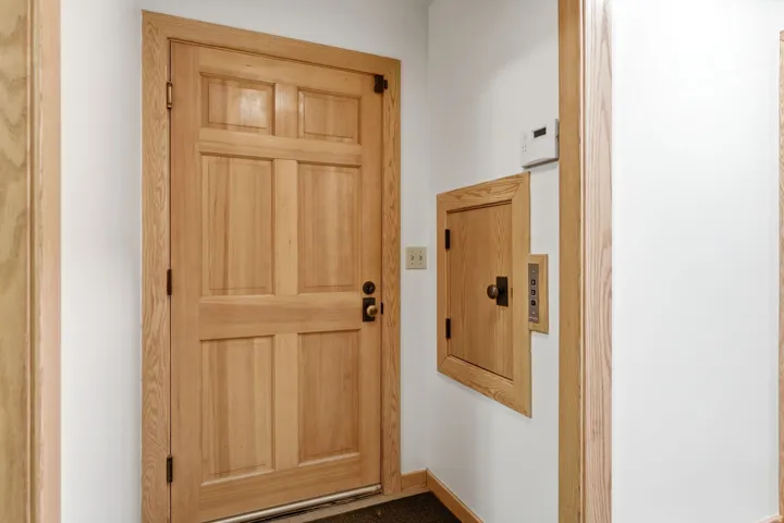 Solid wood interior door with panel detailing and dark bronze hardware