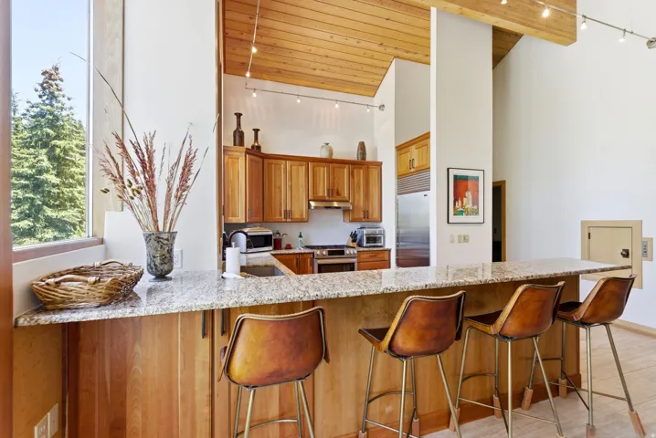 Kitchen featuring an expansive granite-top island with wood-finish cabinetry