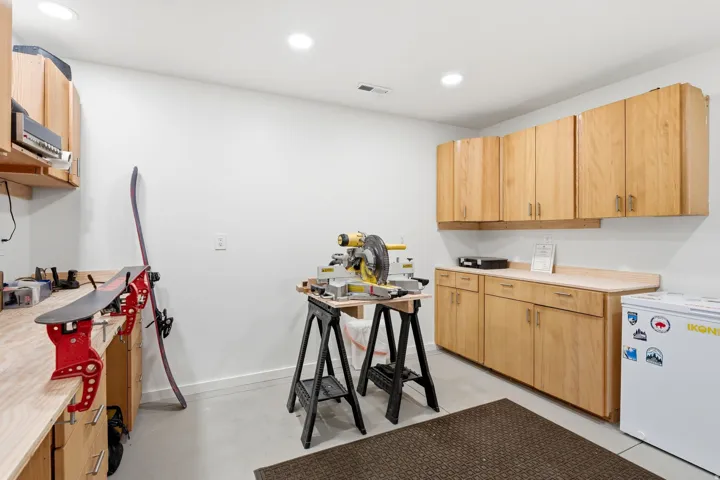 Utility room featuring extensive wood cabinetry, light-toned countertops, and recessed lighting