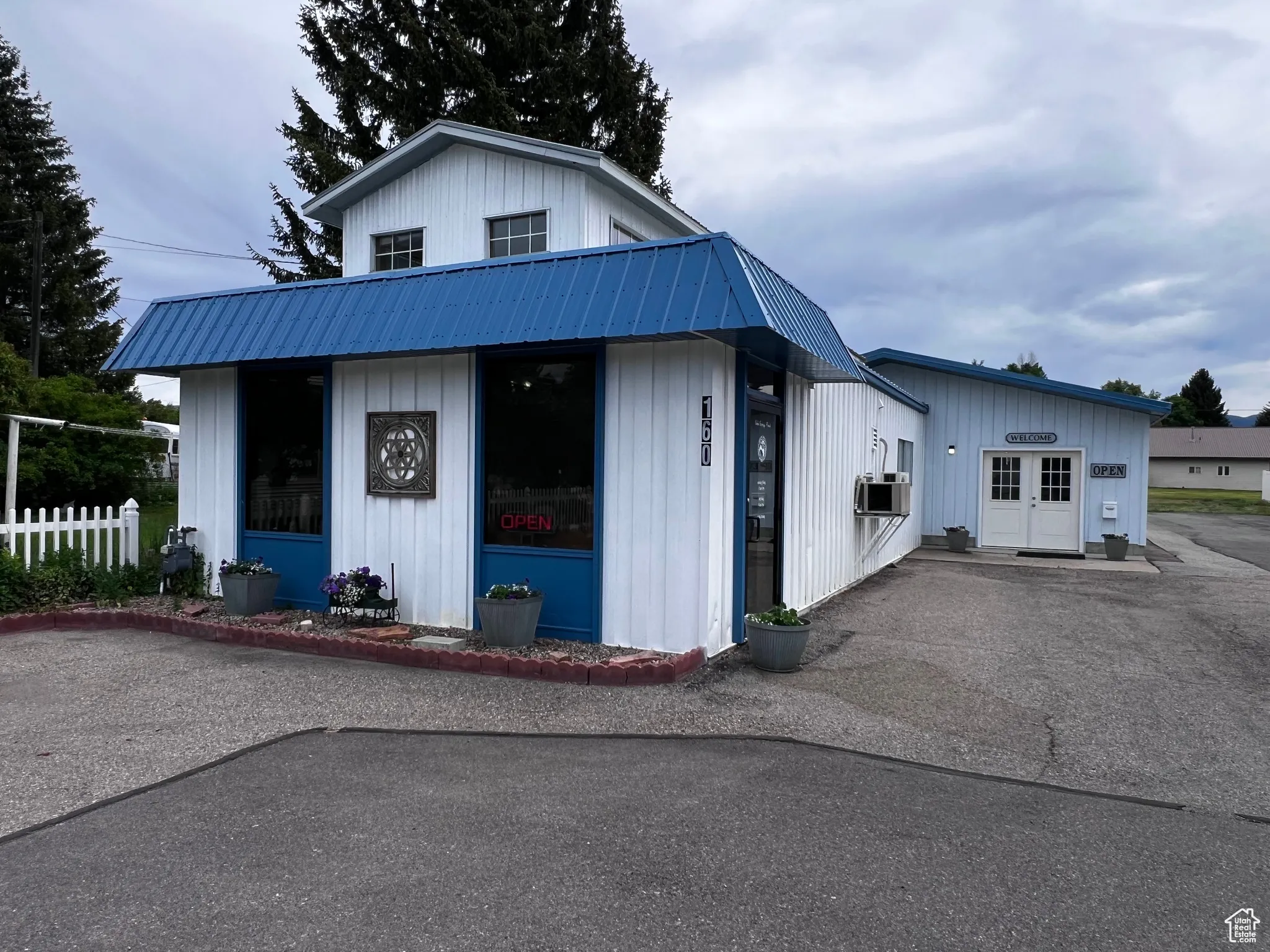 View of front of house with a metal roof, cooling unit, and board and batten siding