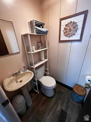 Bathroom featuring wood-type flooring and toilet