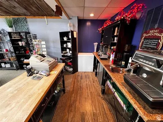 Bar featuring refrigerator, butcher block counters, a drop ceiling, and dark hardwood / wood-style floors
