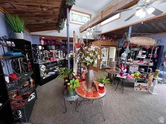 Misc room with ceiling fan, lofted ceiling, and carpet flooring