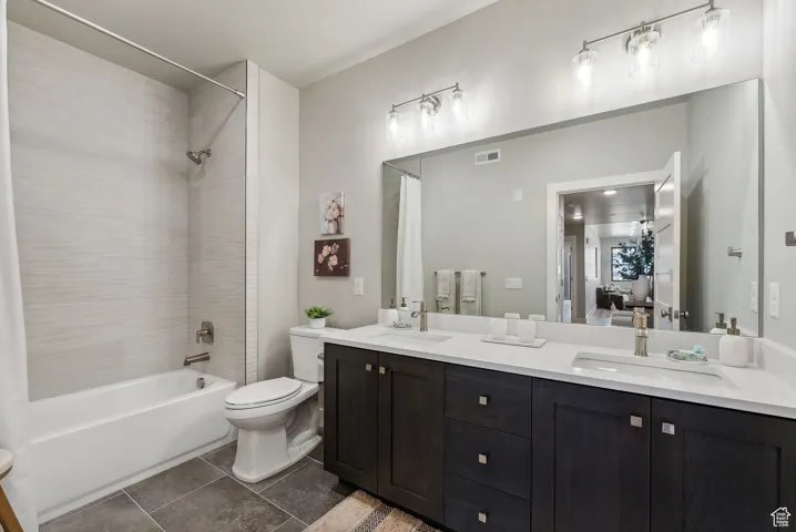 Full bathroom featuring shower / tub combo, vanity, and toilet