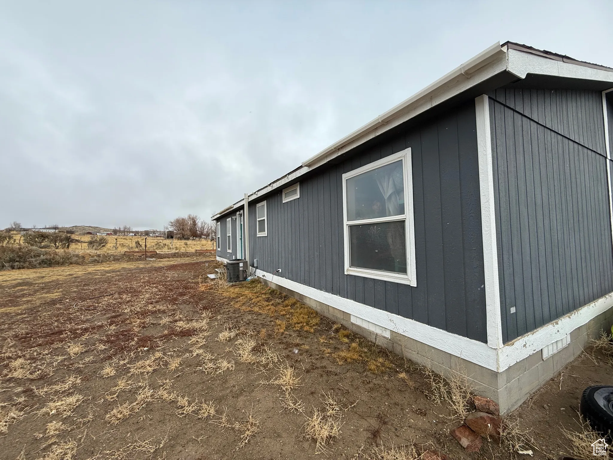 View of side of home with central air condition unit