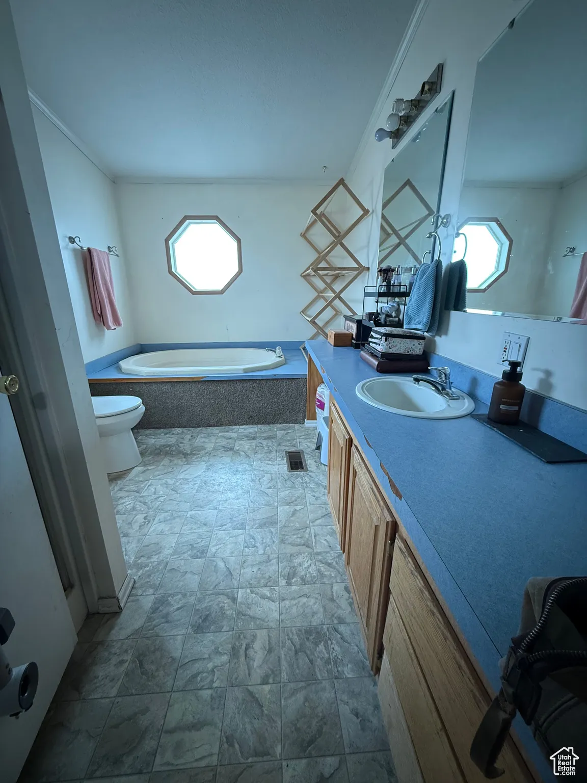 Bathroom with a relaxing tiled tub, vanity, a wealth of natural light, and toilet