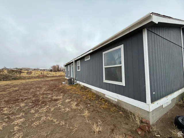 View of side of home with central air condition unit
