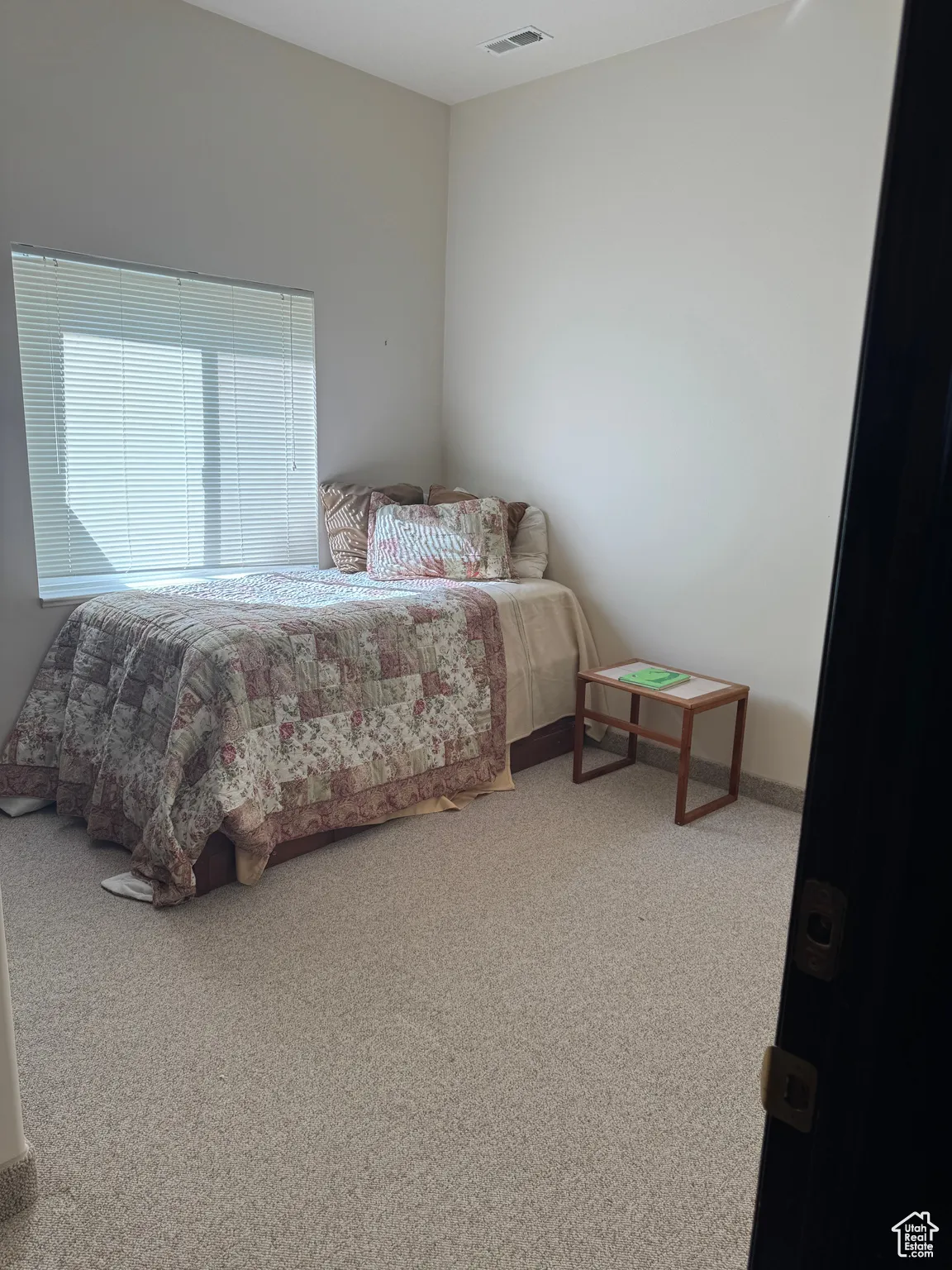 Bedroom with light colored carpet and baseboards