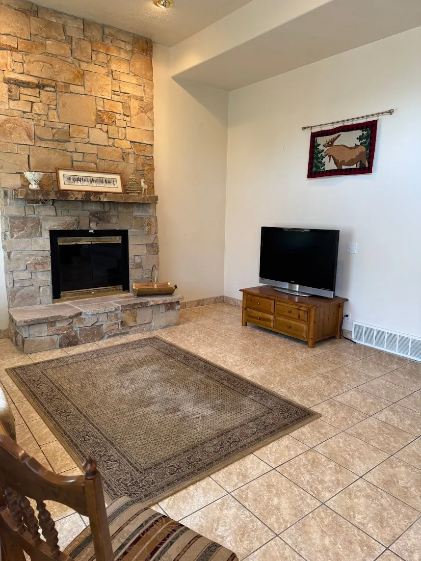 Stacked stone fireplace with a raised hearth, featuring a metal firebox