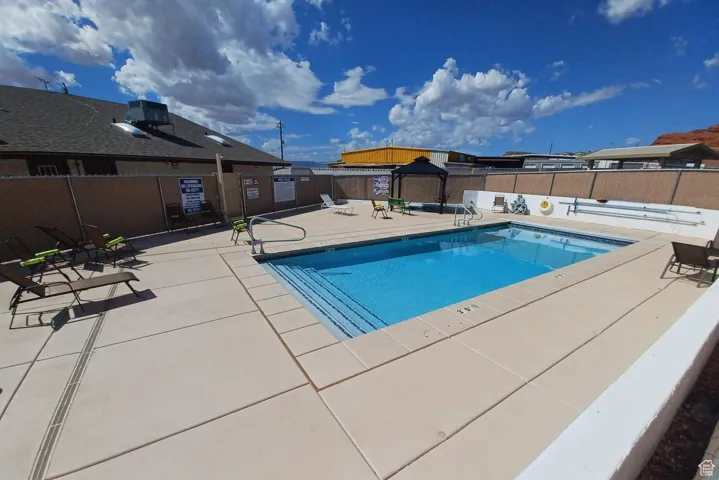 Pool with a patio and fence
