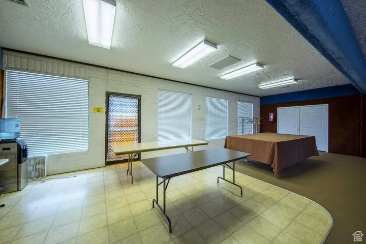 Playroom featuring a textured ceiling, visible vents, and tile patterned floors