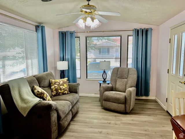Interior space with baseboards, lofted ceiling, and a healthy amount of sunlight