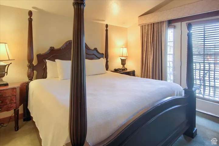 Carpeted bedroom featuring vaulted ceiling