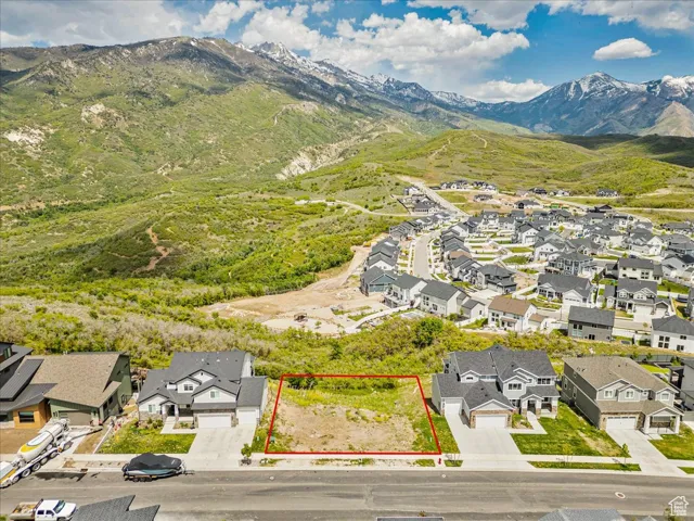 Aerial view of residential area with a mountainous background and property boundaries highlighted