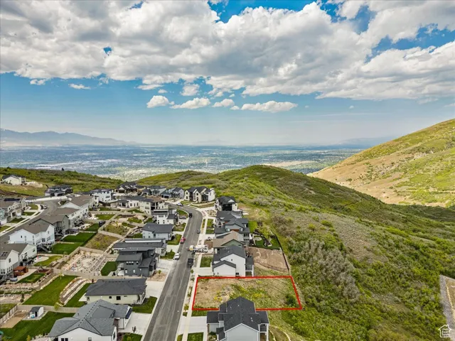 Aerial perspective of suburban area with property parcel outlined and a mountain backdrop