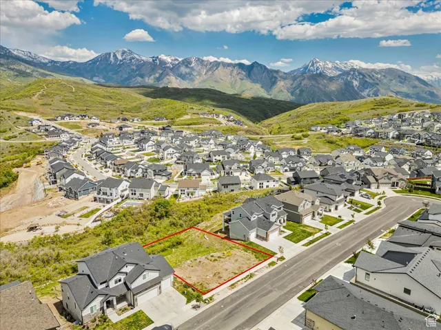 Aerial view of residential area featuring property boundaries highlighted and mountains