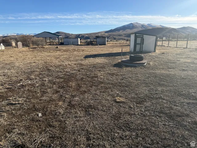 View of yard with a storage unit, a mountain view, and a rural view