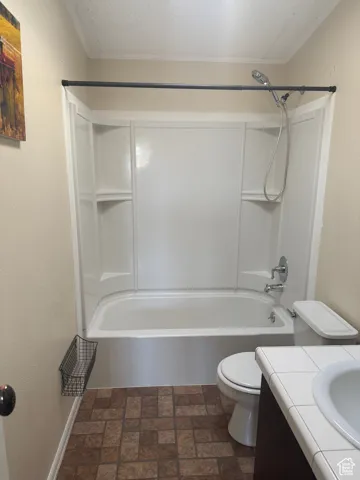 Full bathroom featuring vanity, toilet, bathing tub / shower combination, and a textured ceiling
