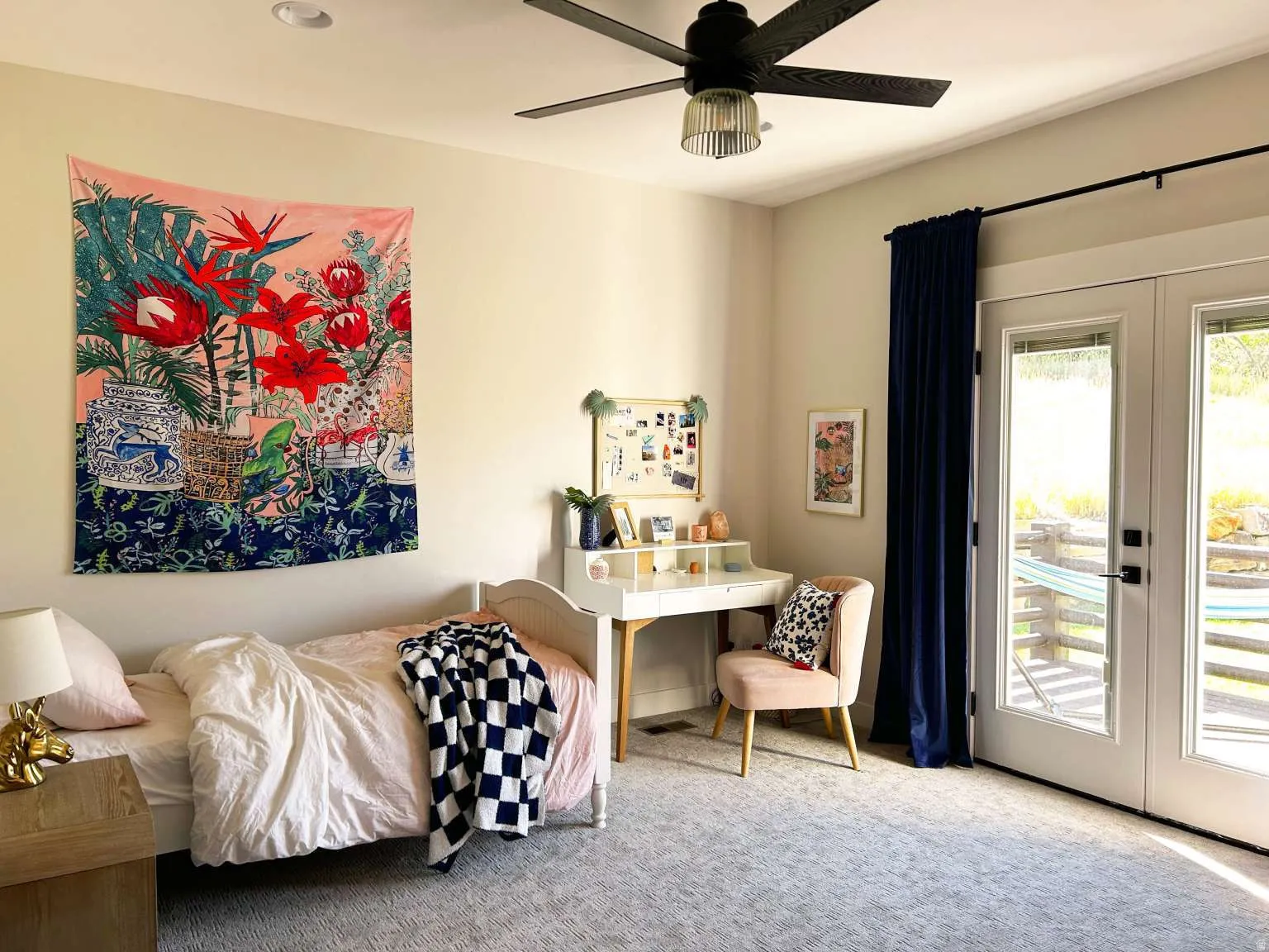 Bedroom featuring light gray carpeting, a built-in ceiling fan with integrated lighting, and white French doors