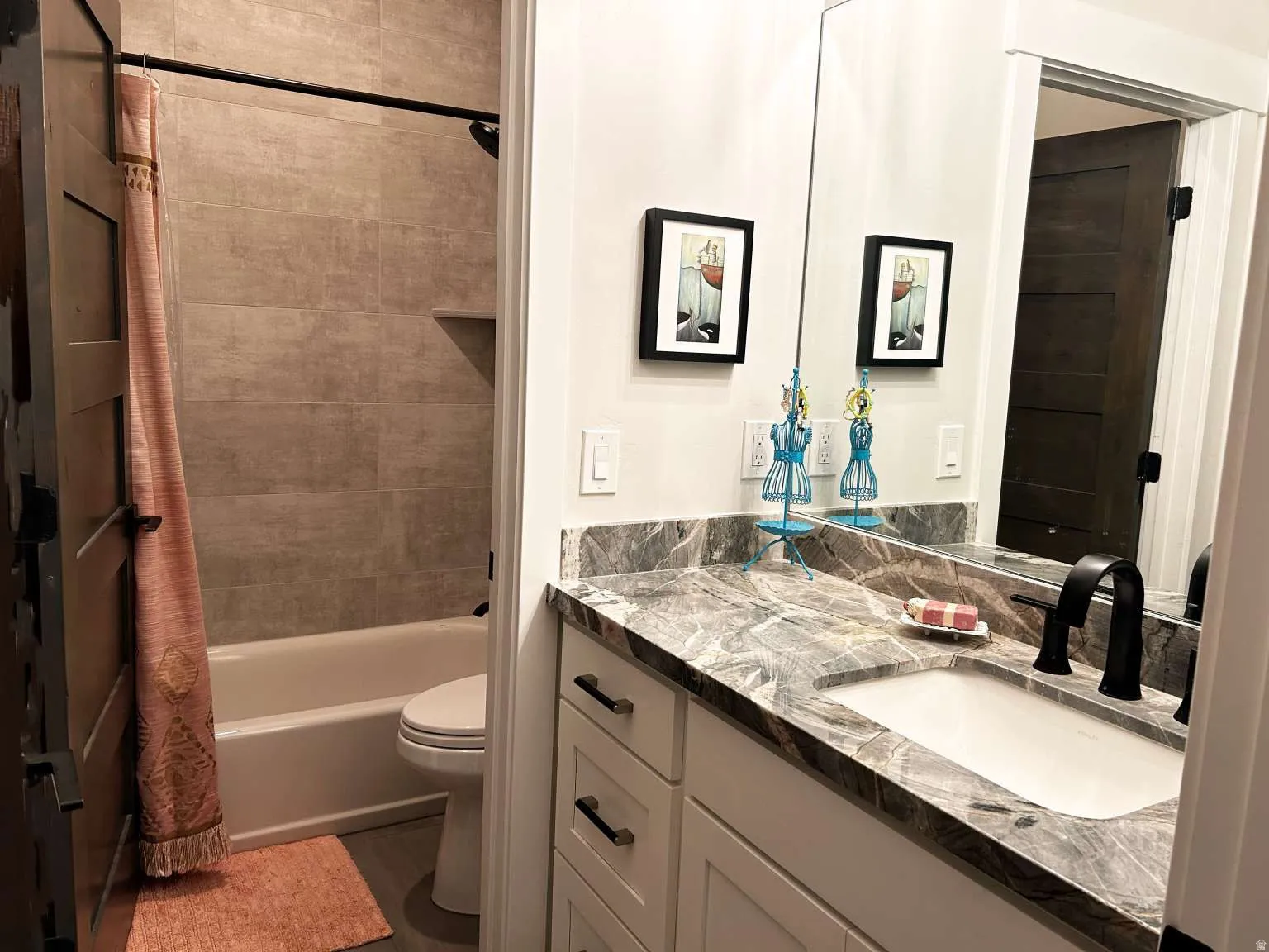 Bathroom featuring a contemporary vanity with a stone countertop, an undermount sink, and a matte black faucet