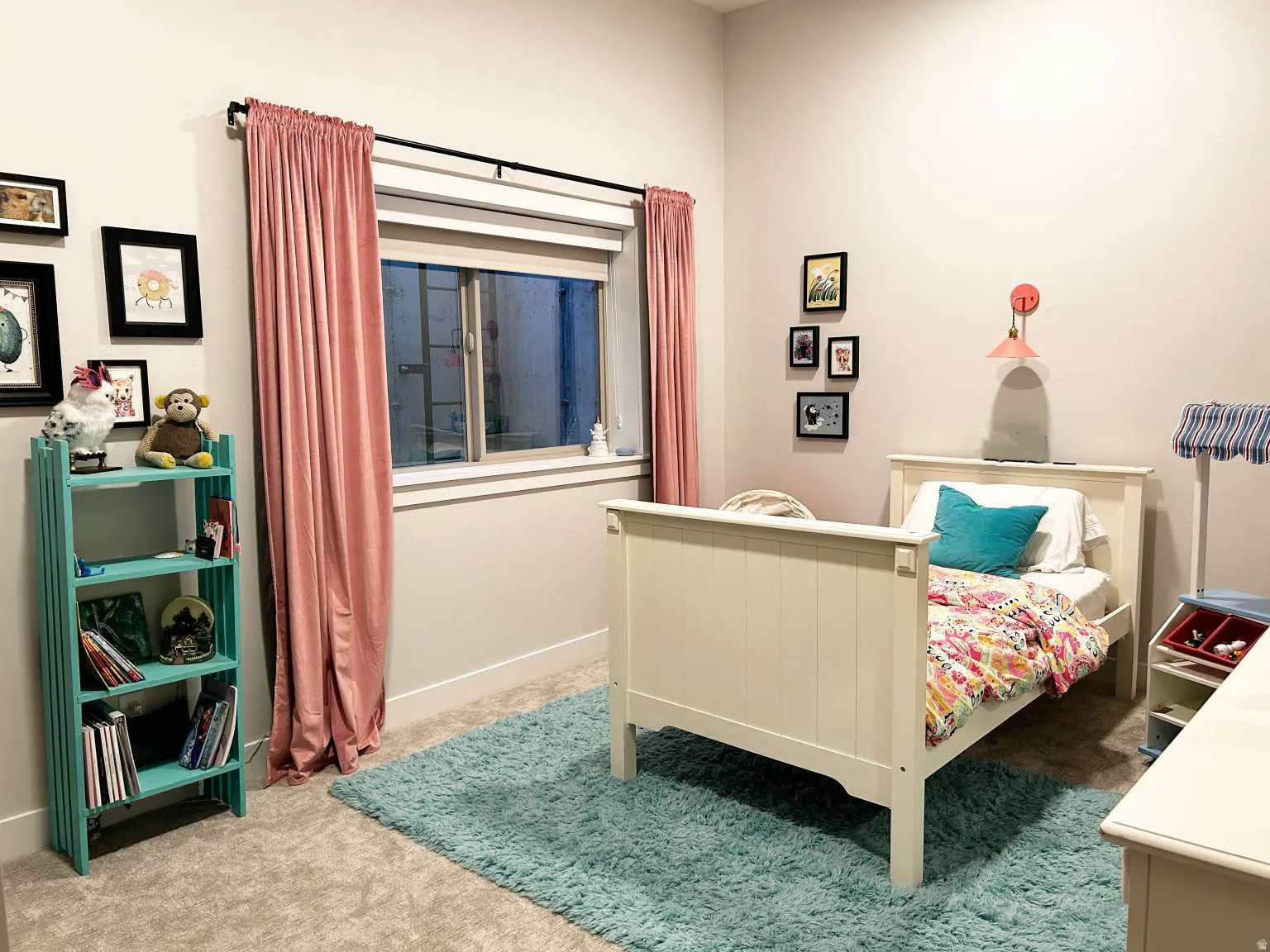 Bedroom featuring light gray wall paint, a window with white trim, and a wall-mounted light fixture
