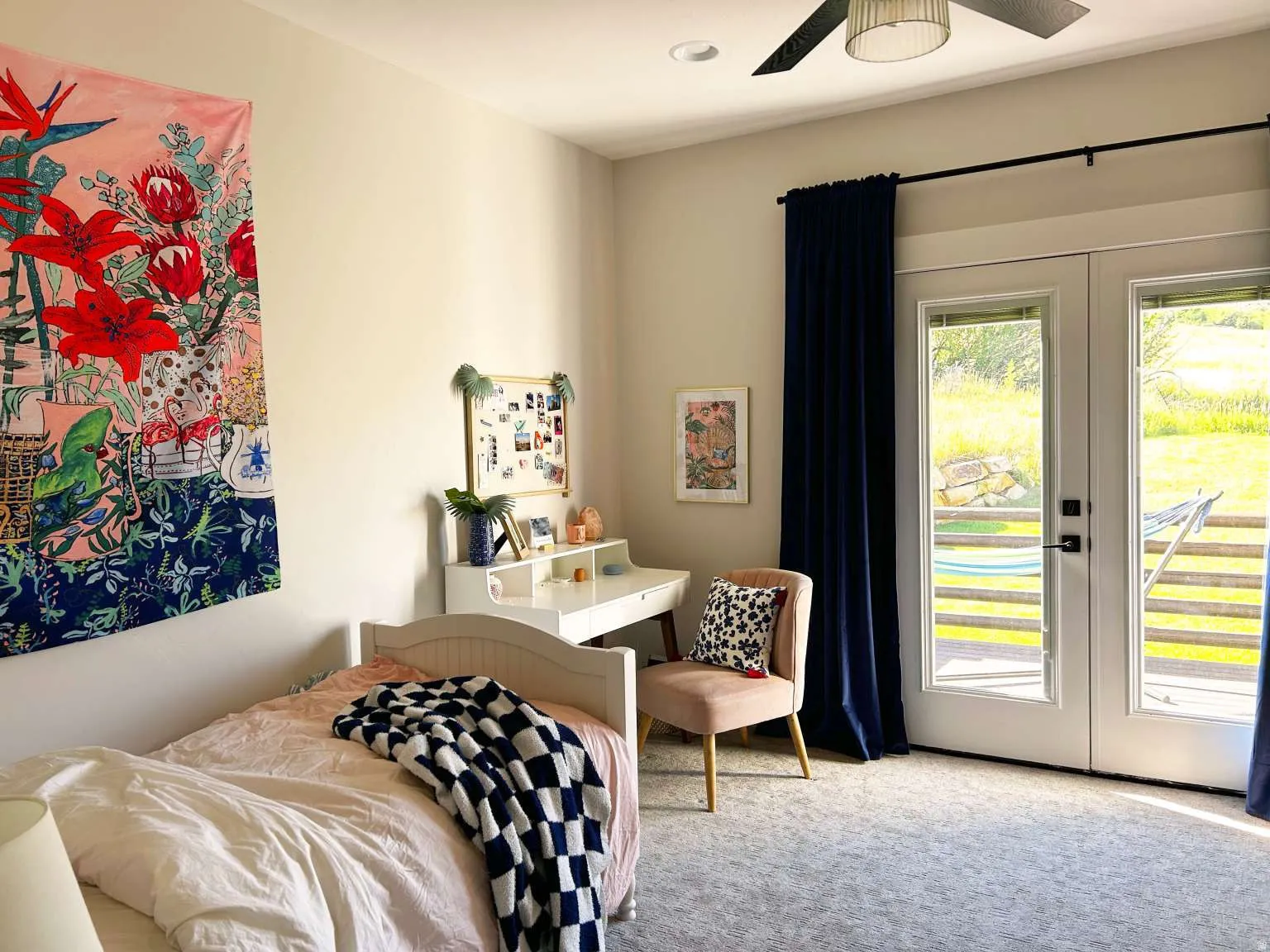 French doors opening to an exterior area, accompanied by a ceiling fan with integrated lighting
