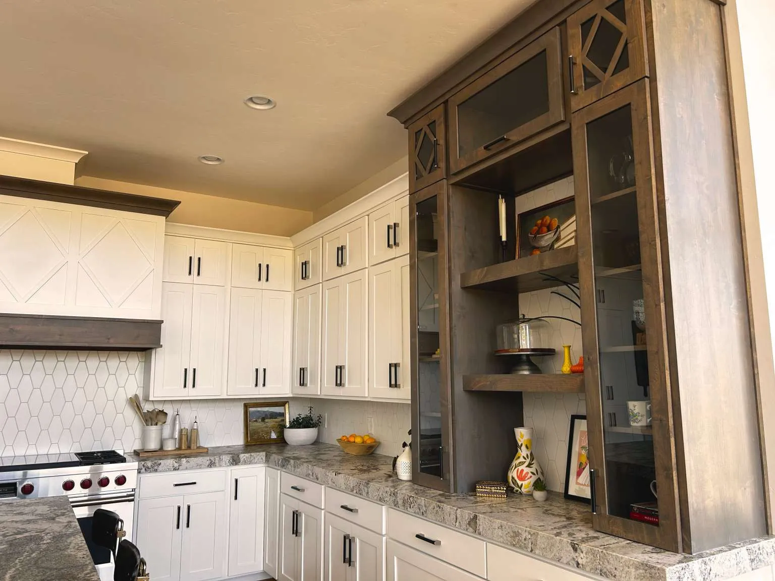 Kitchen featuring white cabinetry and dark wood-finish built-ins with glass-front doors