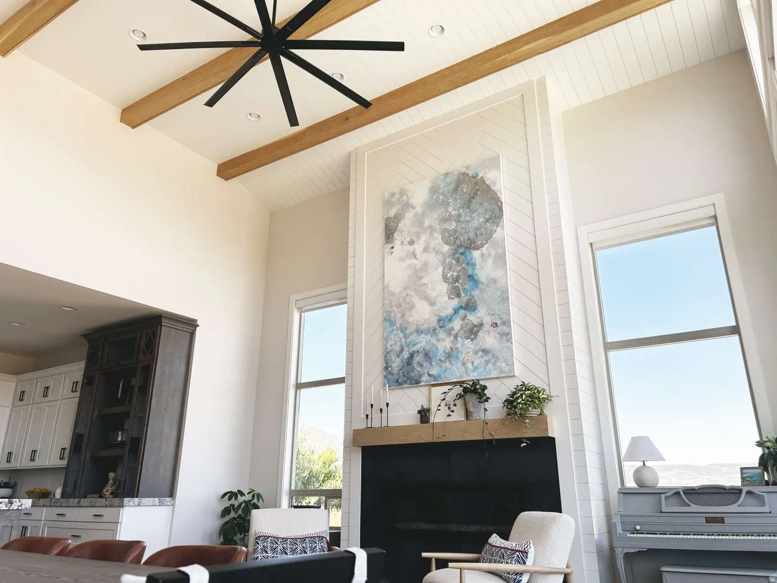 Double-height living space featuring exposed wood beams and shiplap ceiling accents