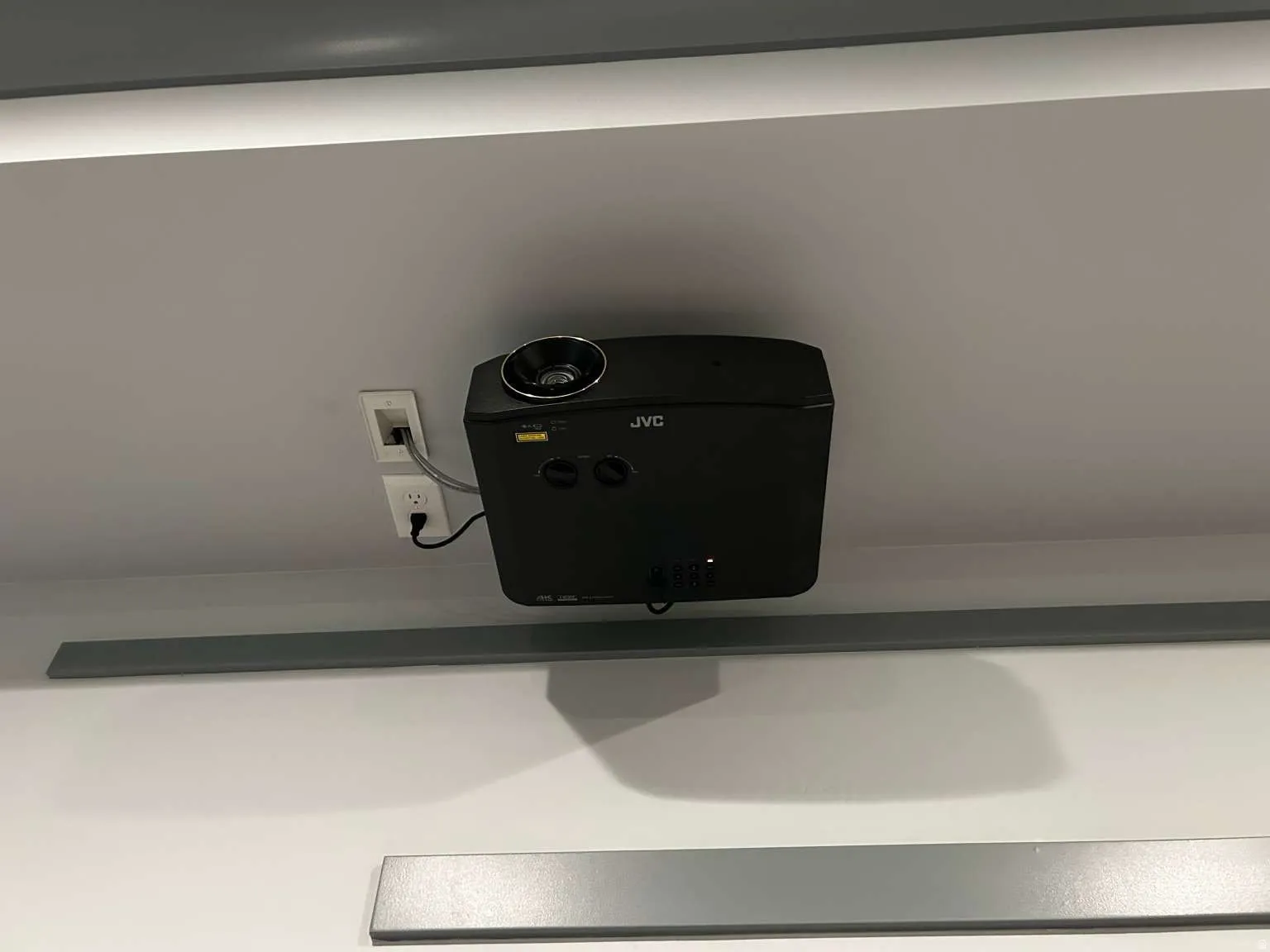 Ceiling-mounted projector with an integrated electrical outlet and network port