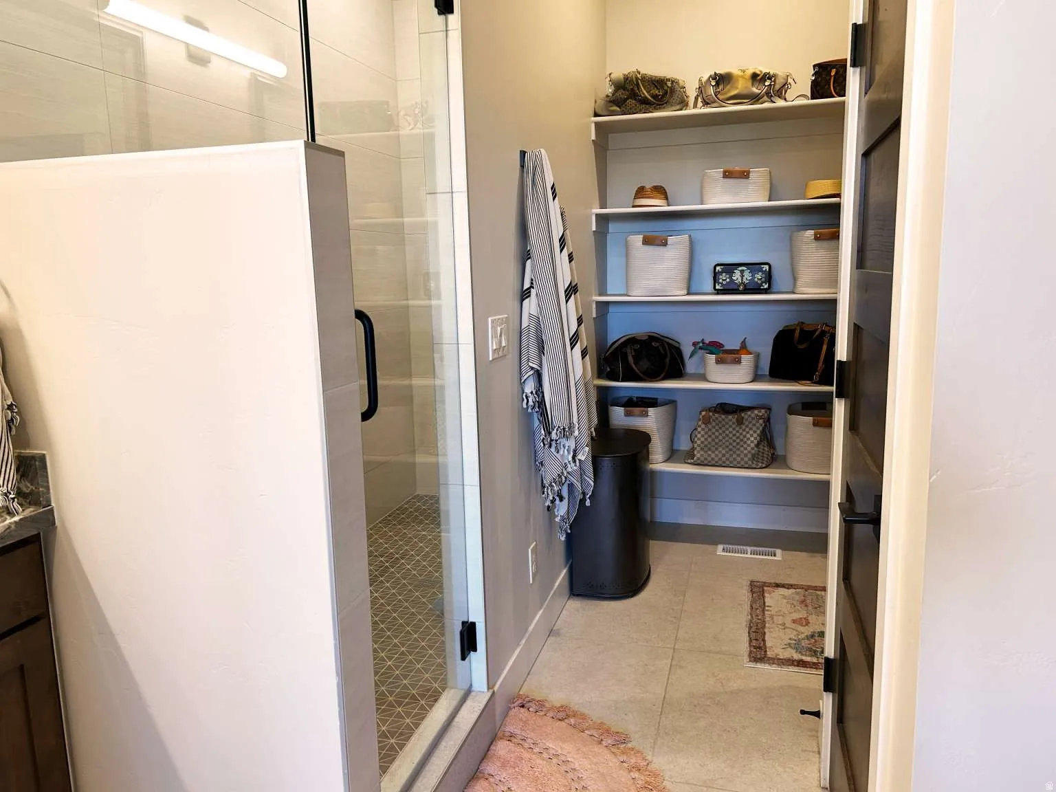 Walk-in shower with clear glass enclosure and black hardware
