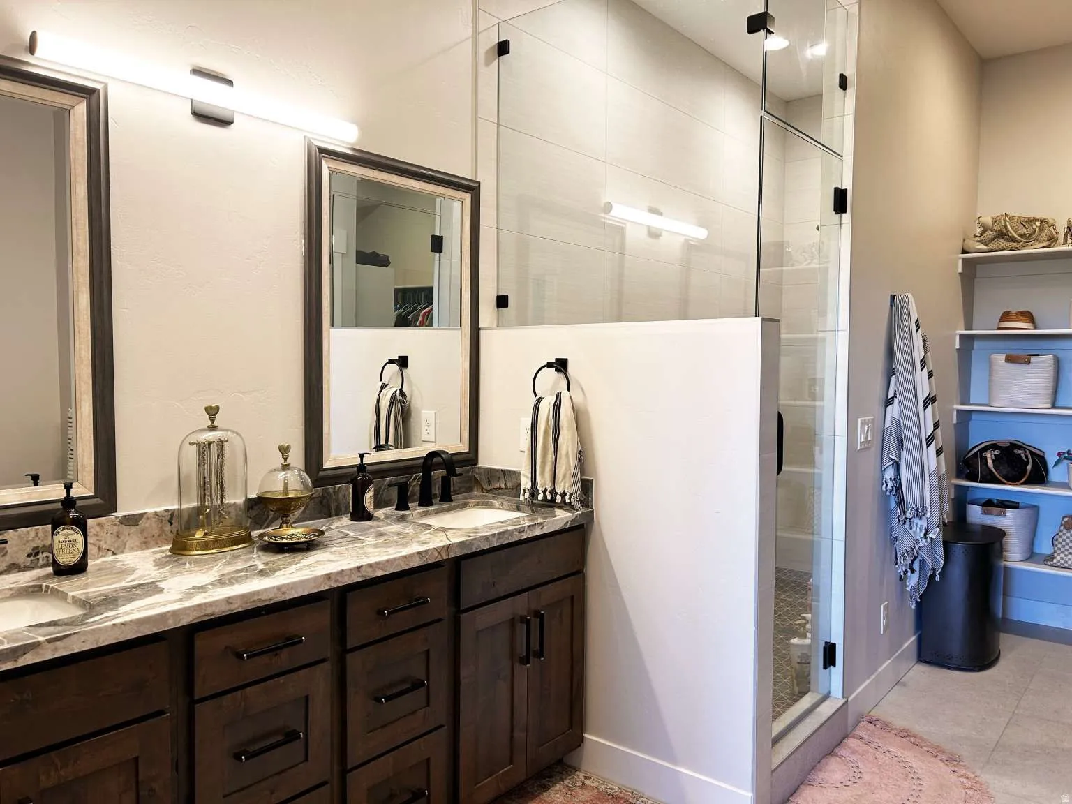 Double vanity with dark wood cabinetry and stone countertops