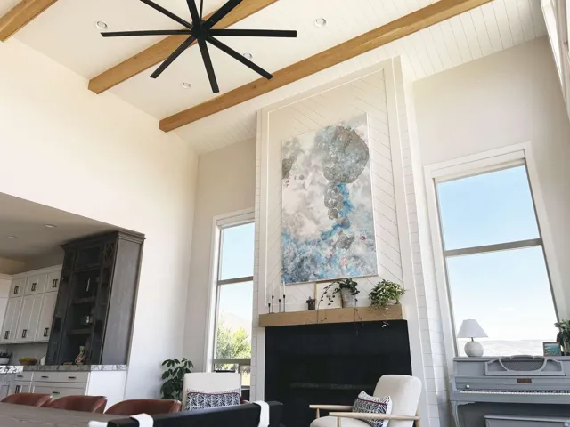 Double-height living space featuring exposed wood beams and shiplap ceiling accents