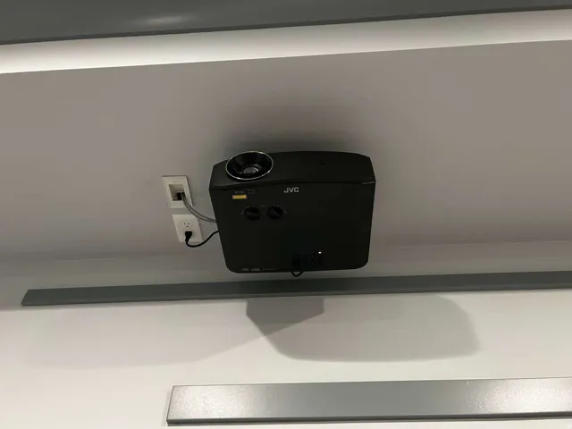Ceiling-mounted projector with an integrated electrical outlet and network port